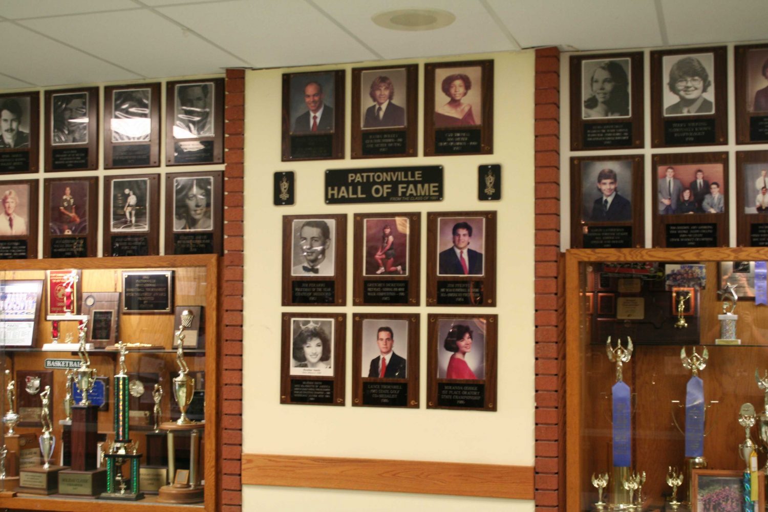 The wall includes pictures of notable alumni and trophies and awards.