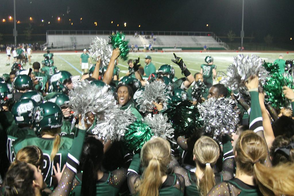 The Pirates celebrate a victory with the cheerleaders and members of the drill team in a 2014 game. (File photo)