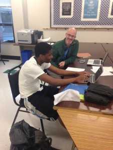 Mr. Frazier helps student on an essay in room D101
