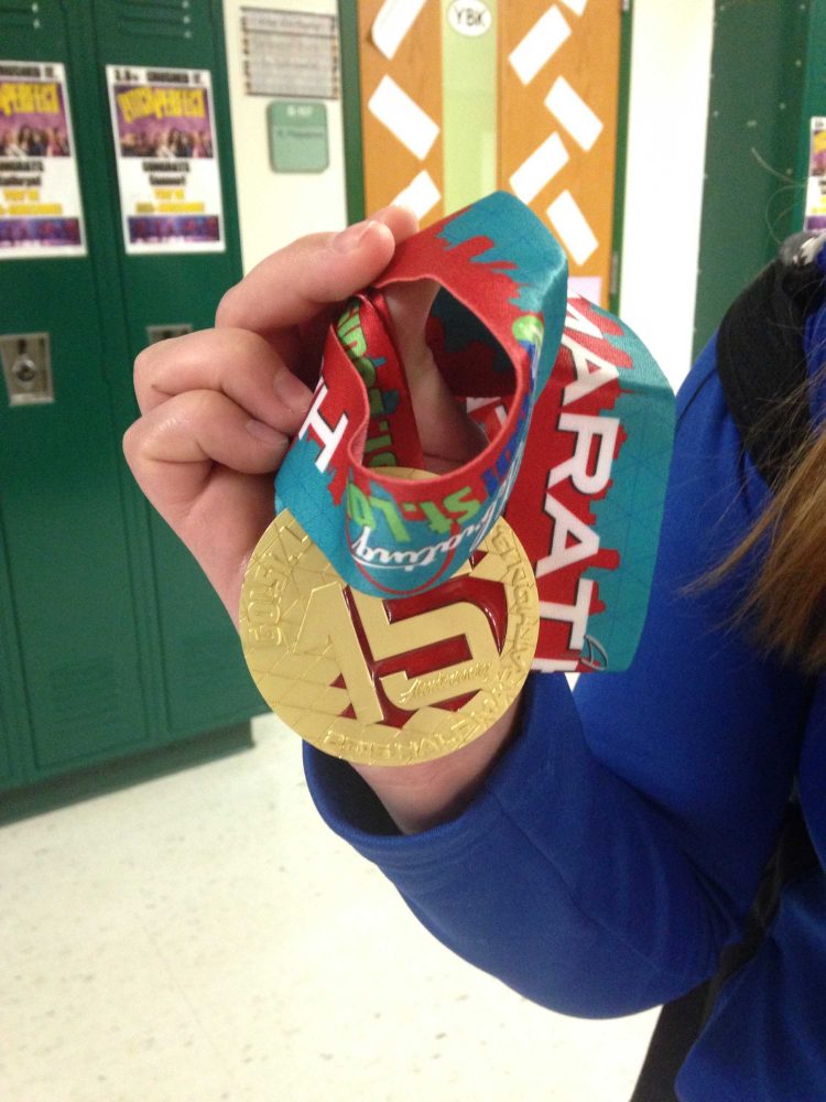 Michelle Cummings displays the medal she won for completing the half marathon.