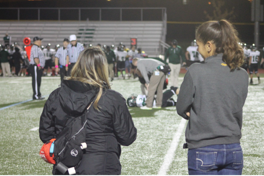 Ms. Sam Keeler (left) stands on the sideline during a 2014 football game (file photo)