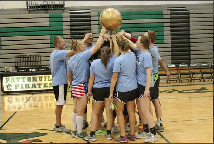 Mr. Victor Fink raises the championship trophy with his team after winning the Dodgeball Tournament. (file photo)