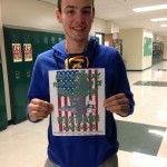Jacob Reese, who is running for 2016-2017 STUCO president, stands in the hallway with one of his campaign posters.