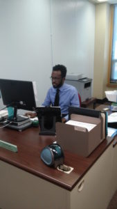 Mr. Leon Douglas sits at his desk in Ms. Odetta Smith's office in the H-wing.