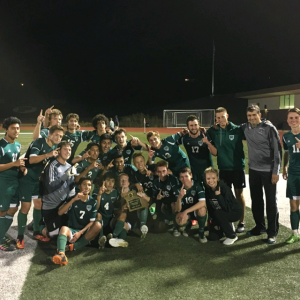 The varsity boy's soccer team takes a picture with the district trophy after winning the game 1-0. (Submitted photo)