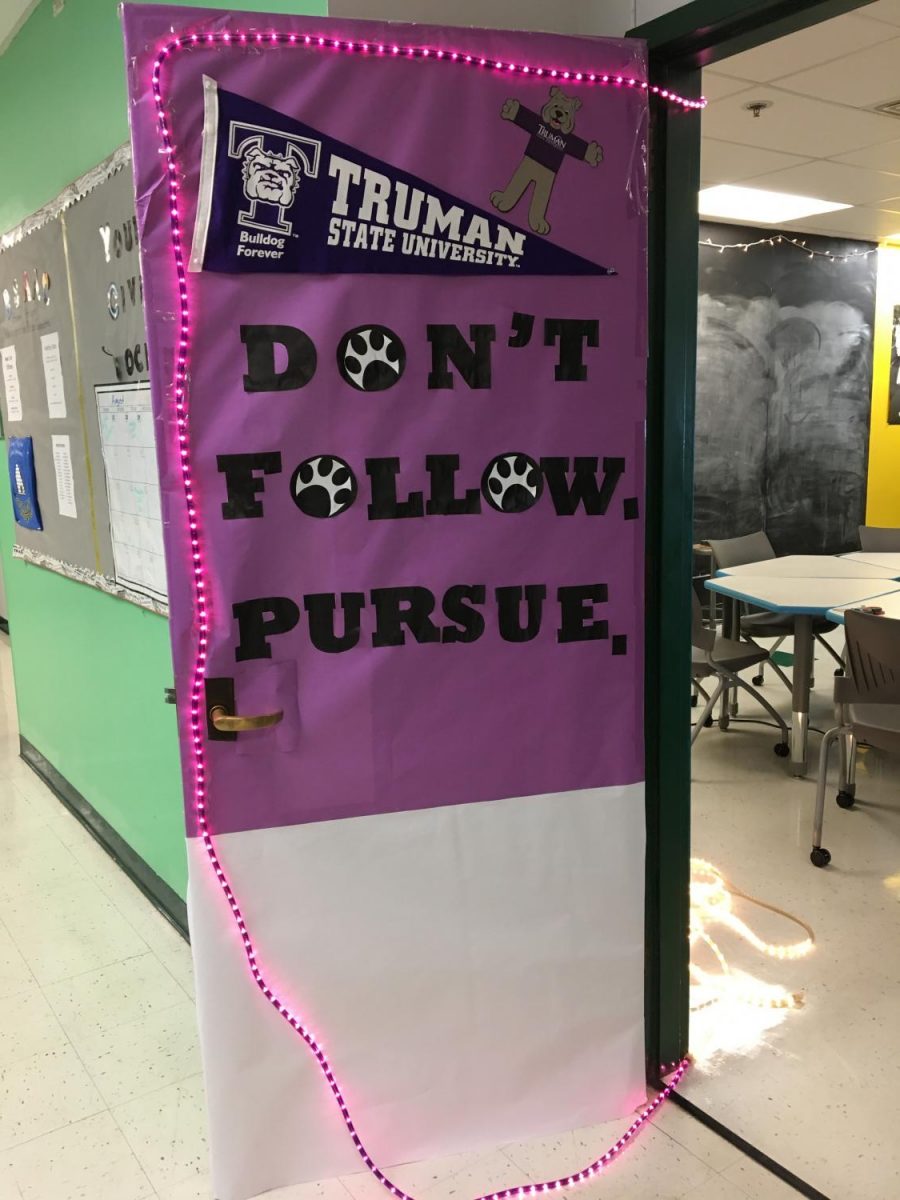 Ms. Jacqueline Saxton decorates her classroom door in the upper D-wing.