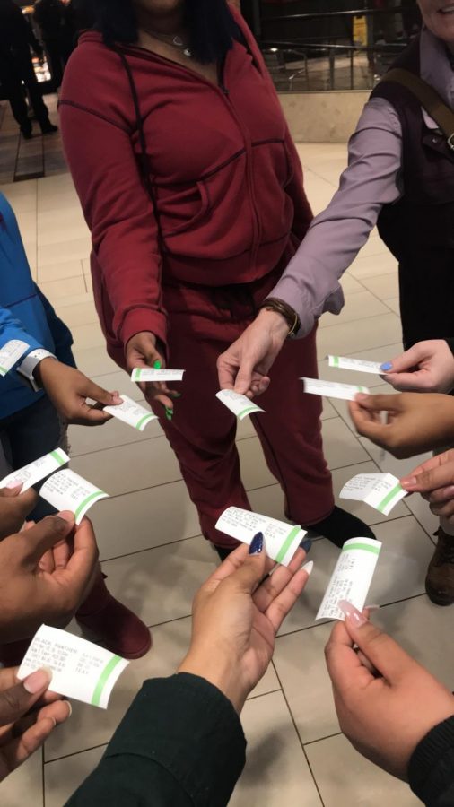 Students hold out their tickets for the movie Black Panther.