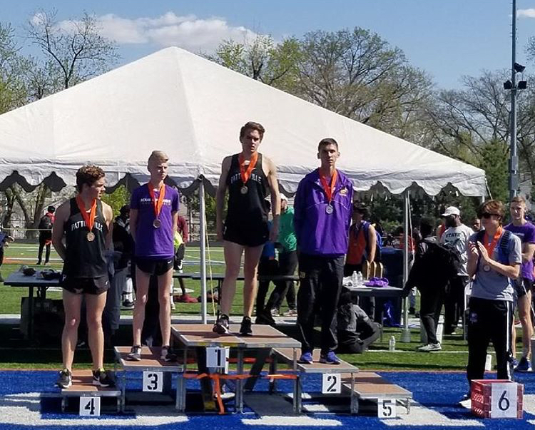 Robert and Lucas Gibson take the podium to receive medals after placing 1st and 4th in the 3200m run.