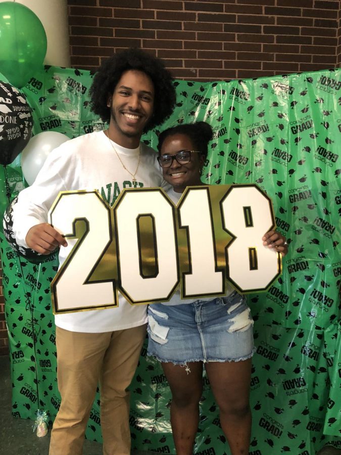 Seniors Yohanes Mulat and Nichole Ashford pose with 2018 prop in National Decision Day photo booth 