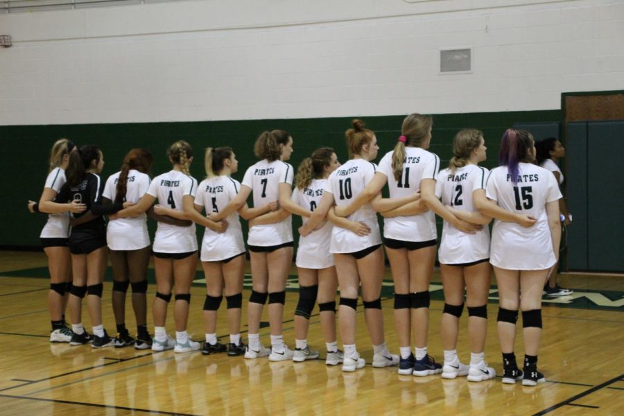The volleyball team lines up for the singing of the National Anthem before a home match. 