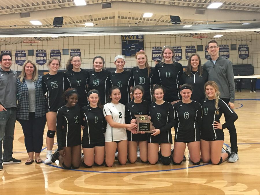 The girls volleyball team holds the Class 4 District 5 championship trophy. 