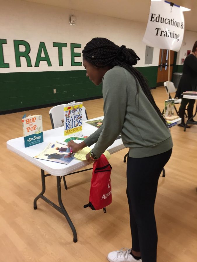 A student looks at materials available at the Career Fair table for those interested in becoming an educator. 