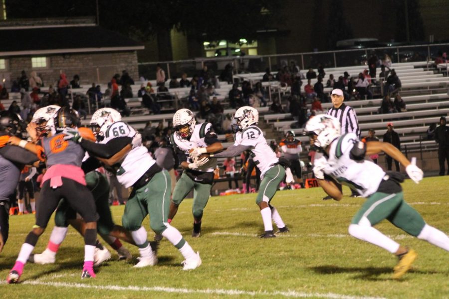 Quarterback Andre Webb hands the ball off to running back Sam Sanderson. 