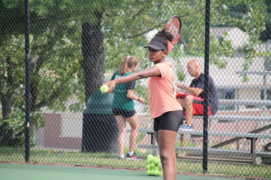 Imani Warren, 11th grade, concentrates on perfecting her toss for her serve. 