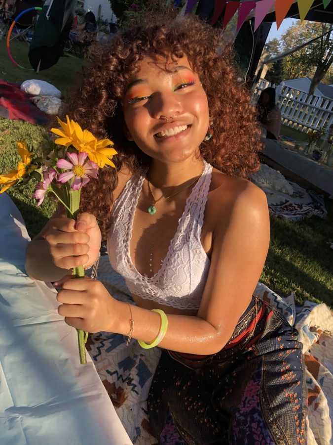 Taken by her mother, Chi Mach, Lauren Banks smiles at the camera while holding a vibrant flower.   
