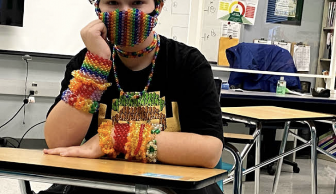 Freshman Dylan Fontana creates masks that fit with their outfit. They spent two days to create the rainbow-themed kandi bracelets and mask.