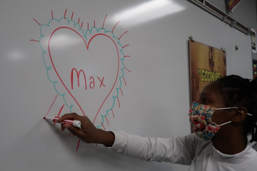 Tajh Martin draws a fun festive heart with Max written in the center of it. Max is the name of the grinchs beloved dog. 