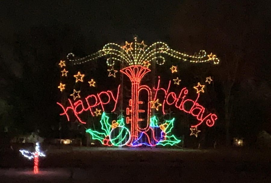 Music flows out of a trumpet with ornaments and hollies. 