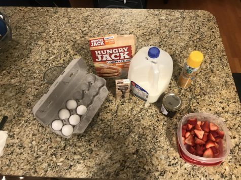 The ingredients, along with strawberries and jam for topping.  You’ll need 1 egg, 1 and ½ cup milk, 1 cup pancake mix, and 1 tsp vanilla.
