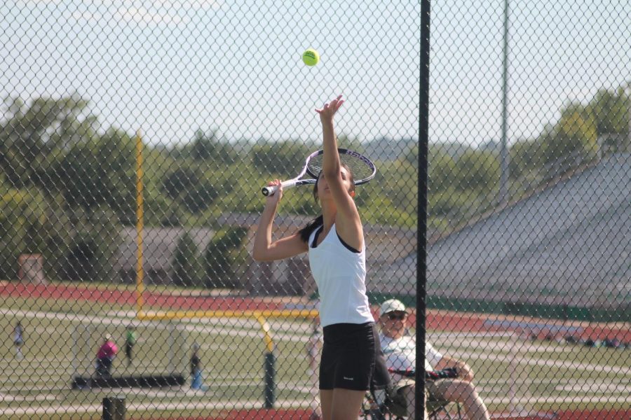 Maichi Ngyuen practices her serve before the match against St. Charles West. The team went on to win 6-3.