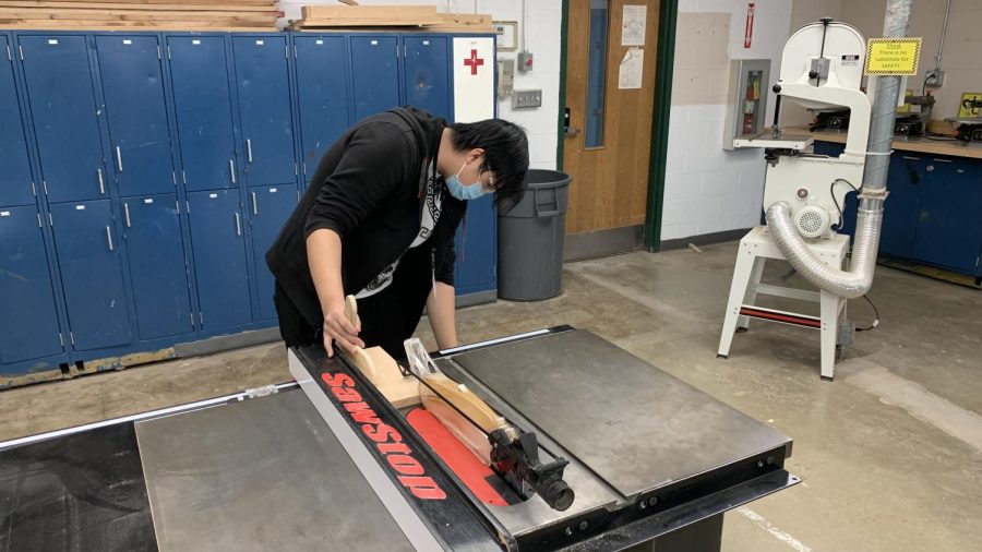 Kyle Huynh sets up the table saw in Woodworking. Students used this tool after the jointer for precision work.