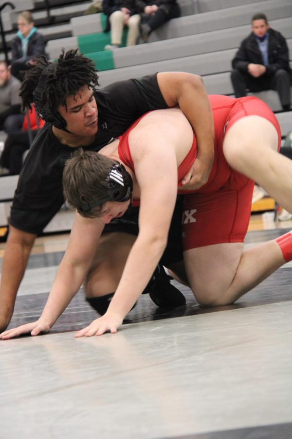 Daniel Davis locking his arm around his opponent, a Fox High wrestler.  