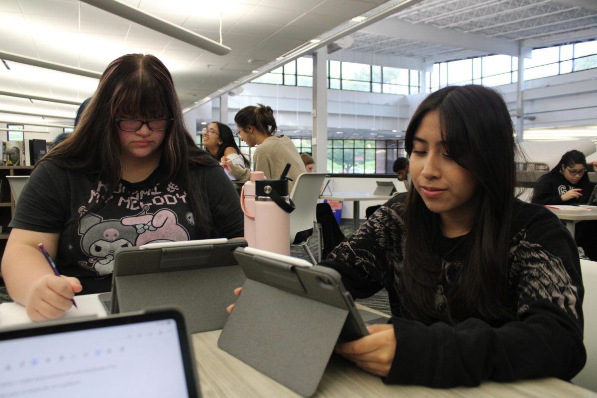 While working in the library on their iPads, Gabrielle Dockery (10) and Ximena Mateo Campos (10) focus and get their work done. Campos shared her tips on staying focused in the library. "You need to be respectful of where you are and make sure it is a place you can get your work done in. If you set goals on what you want to get done and when you want to get it done, you will be able to succeed more."